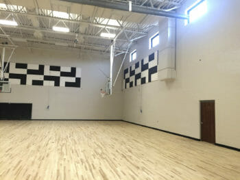Sound Silencer material by Acoustical Surfaces being installed in a gym.